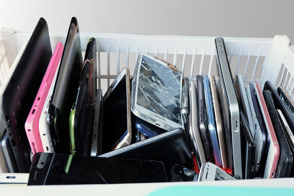 Contenedor de viejos teléfonos inteligentes rotos en una cesta